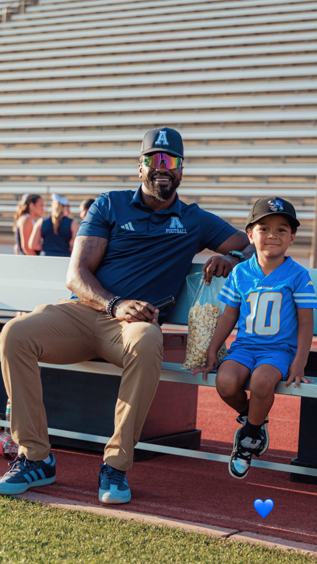 Shareece Wright on the bleachers at Aquinas HS with young fan